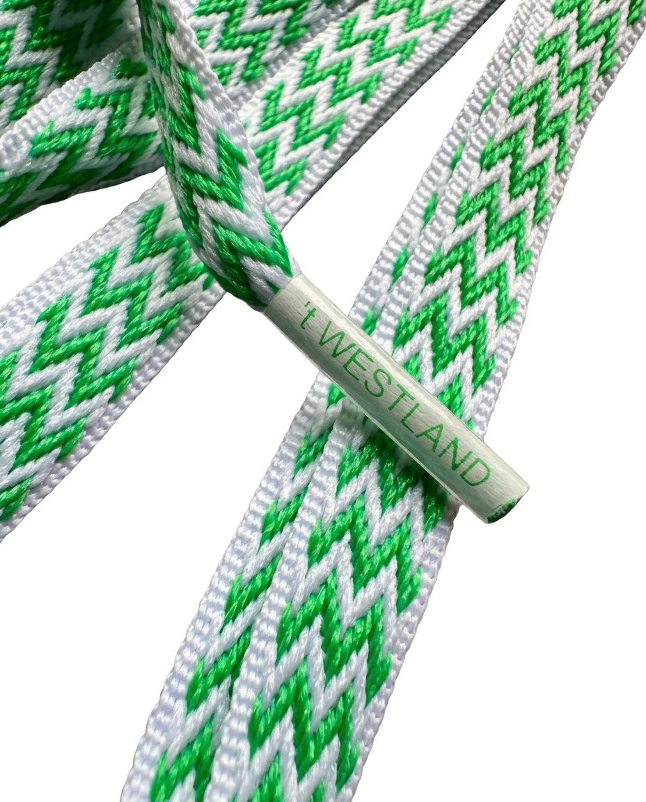 Close-up van de groen-witte Westlandse veter met het tipje met de tekst 't WESTLAND